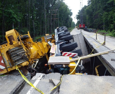 Export Logistics & Shipping, Inc. Liebherr LTM1250 crane has fallen into a pothole